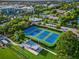 Aerial view of pristine community tennis courts surrounded by lush landscaping at 1242 Whisper Dr, Largo, FL 33770