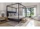 Serene bedroom with a four-poster bed, large windows, and ample natural light at 125 Avonwood, Tampa, FL 33625