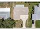 Aerial view showcasing the home's roof, driveway, surrounding yard, and nearby neighborhood at 13883 Jamaica Dr, Seminole, FL 33776