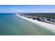 Beautiful aerial view of the stunning coastline, showing the sandy beach and waterfront buildings under a clear sky at 13883 Jamaica Dr, Seminole, FL 33776