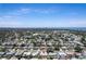 Expansive aerial view displaying a community nestled amongst mature trees with the ocean visible in the distance at 13883 Jamaica Dr, Seminole, FL 33776