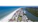 Expansive aerial view showcasing the coastline, beach, and road lined with buildings near the waterfront property at 13883 Jamaica Dr, Seminole, FL 33776
