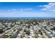 Stunning aerial view showcases the community homes, lush greenery and a distant view of the ocean at 13883 Jamaica Dr, Seminole, FL 33776