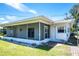 Exterior view of home featuring a screened-in porch, surrounded by lush greenery and a well-maintained lawn at 13883 Jamaica Dr, Seminole, FL 33776