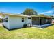 The home's exterior includes a screened lanai, offering a relaxing outdoor space with views of the green lawn at 13883 Jamaica Dr, Seminole, FL 33776