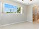 Bright bedroom with natural light streaming through the large window and door leading to the bathroom at 13883 Jamaica Dr, Seminole, FL 33776