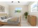 Relaxing bedroom with a plush bed, natural light, complemented by stylish décor and a serene window view at 13883 Jamaica Dr, Seminole, FL 33776