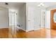 Spacious entryway with wood floors and a view of the hallway and wooden door at 13883 Jamaica Dr, Seminole, FL 33776