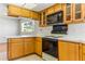 Kitchen with wooden cabinets, white countertops, and essential appliances at 13883 Jamaica Dr, Seminole, FL 33776
