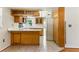 Spacious kitchen with white appliances, wood cabinets, and tiled flooring at 13883 Jamaica Dr, Seminole, FL 33776