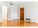 Living room with wood floors, white walls, closet, and front door at 13883 Jamaica Dr, Seminole, FL 33776