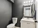 This bathroom features a modern sink, mirror, and toilet with gray accent walls at 1508 Adams E Cir, Largo, FL 33771