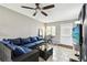 Well-lit living area with large sofa, fan, and access to the backyard at 1508 Adams E Cir, Largo, FL 33771