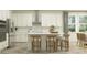Modern kitchen with stainless steel appliances, white cabinets, and an island with bar stool seating at 1554 Serenity Outlook Ct, Lutz, FL 33548