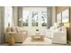 Cozy living room with comfortable seating, soft lighting, and large windows overlooking lush greenery at 1554 Serenity Outlook Ct, Lutz, FL 33548