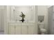 Bright bathroom with white cabinetry, double sinks, marble countertops, and decorative plant accents at 18137 Serene Lake Loop, Lutz, FL 33548