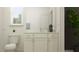 Well-lit bathroom with white cabinetry, a marble countertop, decorative plant accents, and a large mirror at 18137 Serene Lake Loop, Lutz, FL 33548
