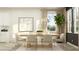 Dining room with a wood table, stylish chairs, modern art, and a large plant near the bright windows at 18137 Serene Lake Loop, Lutz, FL 33548