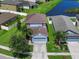 Two-story home featuring an attached garage, lush green lawn and a serene pond view at 1821 Hawks View Dr, Ruskin, FL 33570
