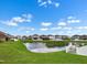 Scenic backyard view featuring a tranquil pond and lush green lawn at 1821 Hawks View Dr, Ruskin, FL 33570