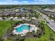 Aerial view of the community pool area with lush landscaping, palm trees, and nearby homes at 1821 Hawks View Dr, Ruskin, FL 33570