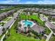 Aerial view of the community pool area, featuring palm trees and lounge chairs at 1821 Hawks View Dr, Ruskin, FL 33570