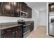Modern kitchen with stainless steel appliances, granite countertops and dark wood cabinets at 1821 Hawks View Dr, Ruskin, FL 33570