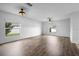 Open living room with wood-look floors, lots of natural light and two ceiling fans at 1821 Hawks View Dr, Ruskin, FL 33570