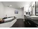 Elegant bathroom with double sinks, sleek black cabinetry, and a soaking tub at 2 Seaside Ln # 203, Belleair, FL 33756