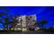 Exterior view of the well-maintained condo building featuring lush landscaping and ample parking at 2 Seaside Ln # 203, Belleair, FL 33756