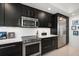 Modern kitchen featuring sleek black cabinetry and stainless steel appliances at 2 Seaside Ln # 203, Belleair, FL 33756