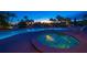 Community pool and hot tub at dusk with tropical landscaping and cozy lighting at 2 Seaside Ln # 203, Belleair, FL 33756