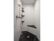 Walk-in shower with white subway tile walls, black tile floor, and a built-in corner seat at 2 Seaside Ln # 203, Belleair, FL 33756
