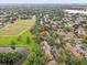 An aerial view shows the property nestled among trees with nearby baseball fields and tranquil pond, creating a convenient locale at 2078 Sunset Point Rd # 83, Clearwater, FL 33765