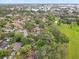 An aerial view shows the property surrounded by lush greenery, a pond, and community baseball fields at 2078 Sunset Point Rd # 83, Clearwater, FL 33765