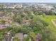 An aerial view showcases the property nestled among lush greenery and a tranquil pond, offering a serene setting at 2078 Sunset Point Rd # 83, Clearwater, FL 33765