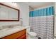 Bathroom features a vanity with a granite countertop and a shower with blue accents at 2078 Sunset Point Rd # 83, Clearwater, FL 33765