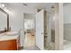 Bright bathroom with modern vessel sink, granite counters, glass-enclosed shower, and an open view to the bedroom at 2078 Sunset Point Rd # 83, Clearwater, FL 33765