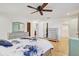 This bedroom features a dresser, doors to a bathroom, and ceiling fan at 2078 Sunset Point Rd # 83, Clearwater, FL 33765