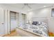 Bright bedroom features a ceiling fan and a closet with built-in shelving and drawers at 2078 Sunset Point Rd # 83, Clearwater, FL 33765