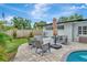 Inviting back patio with a stone fire pit, comfortable seating, and lush landscaping at 2205 N Riverside Dr, Tampa, FL 33602
