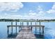 Scenic view of a weathered wooden dock extending into the calm blue water under a partly cloudy sky at 2205 N Riverside Dr, Tampa, FL 33602