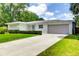 Well-kept one-story home with lush lawn, a long driveway, and attached garage at 2205 N Riverside Dr, Tampa, FL 33602