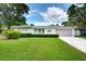 One-story home with a green lawn and mature landscaping, near mature trees at 2205 N Riverside Dr, Tampa, FL 33602
