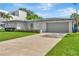 Well-maintained home with an attached garage, a long driveway, and lush lawn at 2205 N Riverside Dr, Tampa, FL 33602