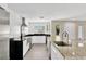 View of kitchen featuring stainless steel appliances, granite countertops, white cabinets and gray tiled floor at 2205 N Riverside Dr, Tampa, FL 33602