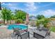 Cozy outdoor space with a sparkling pool, comfortable seating around a fire pit, and lush tropical landscaping at 2205 N Riverside Dr, Tampa, FL 33602