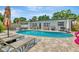 Stunning backyard pool area with modern patio furniture, a built-in grill, and a lush, tropical landscape at 2205 N Riverside Dr, Tampa, FL 33602