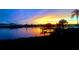 Stunning sunset reflecting over calm waters, complemented by a silhouette of palm trees and a dock at 2205 N Riverside Dr, Tampa, FL 33602