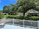 Backyard view with white picket fence, lush landscaping, and mature trees on a sunny day at 2256 Philippine Dr # 24, Clearwater, FL 33763
